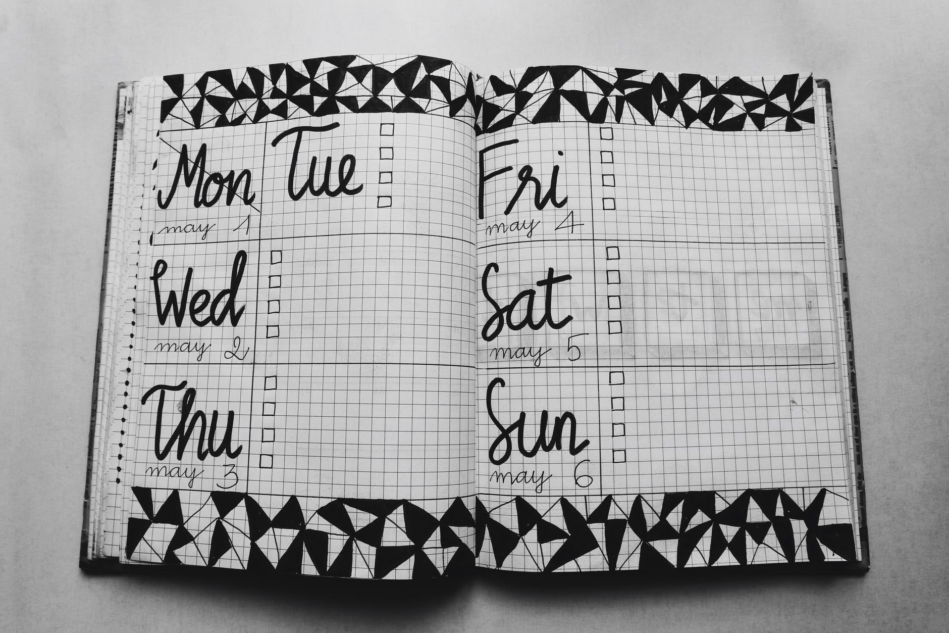 white and black weekly planner on gray surface